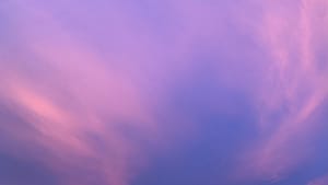 Soft pink and purple sky gradient background with subtle cloud texture