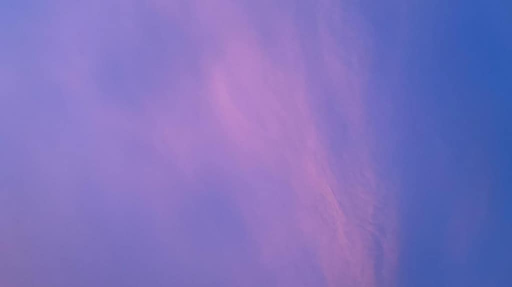 Vibrant purple and pink sunset sky with soft wispy clouds