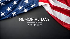 American flag draped on a dark background with Memorial Day text and stars